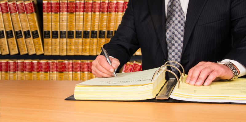 proofreading-lawyer-signing-legal-documents-52665255-min